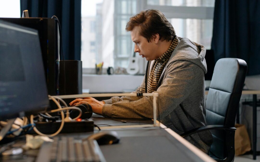 Free A concentrated professional working at a computer in a modern office setting. Stock Photo