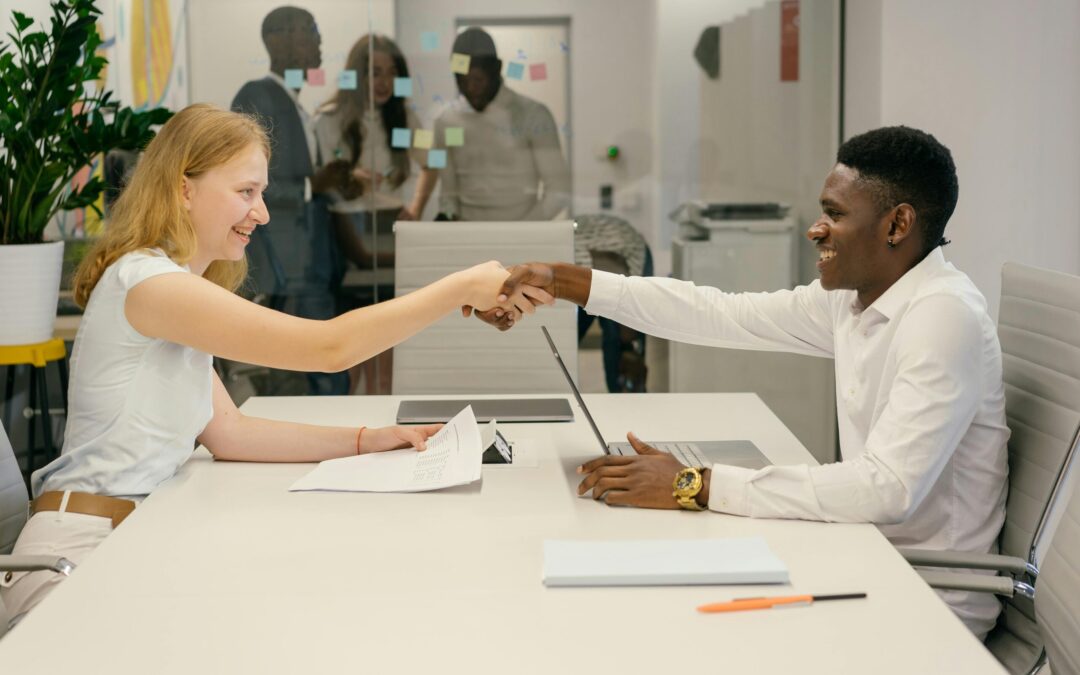 Free Business professionals completing a successful deal with a handshake in a modern office setting. Stock Photo